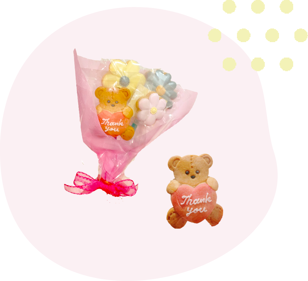 クマとお花のクッキーが４本セットになって、花束のようにラッピングされている写真とサンキューと描かれたクマのクッキー